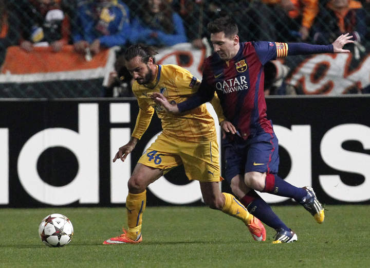 El delantero argentino del FC Barcelona, Lionel Messi (dcha), pelea por el control del balón con el jugador del Apoel, Stathis Aloneftis (izda), durante el partido del grupo F. (EFE)