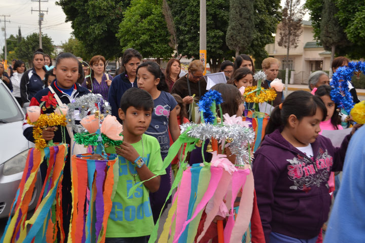 Colorido. Niños y niñas llevan bastones adornados con papel de China, escarcha y fieltro, que representan el que utilizó José.