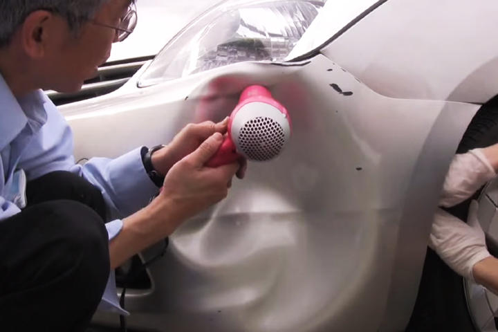 Con ayuda de dos secadoras de cabello el hombre consigue reparar su auto en cuestión de minutos. (YOUTUBE)