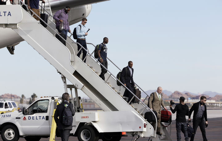 Jugadores del actual campeón de la NFL, Halcones Marinos de Seattle, descienden del avión que los transportó a Phoenix, Arizona, donde disputarán otra final por el trofeo Vince Lombardi. (AP)