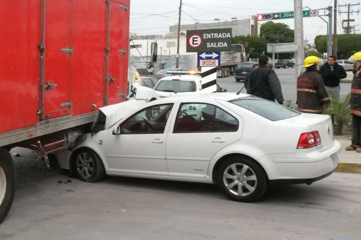 Susto. La conductora del Jetta, perdió el control del auto y terminó debajo del camión.  
