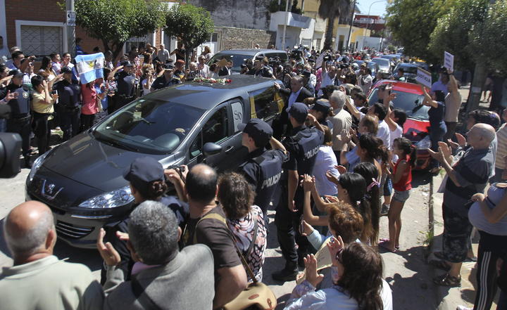 En medio de aplausos, banderas argentinas y gritos de 'Justicia', 'Argentina' y 'Nisman, presente', decenas de personas recibieron el cortejo fúnebre a su llegada al cementerio de La Tablada, rodeado de un fuerte operativo policial. (EFE)
