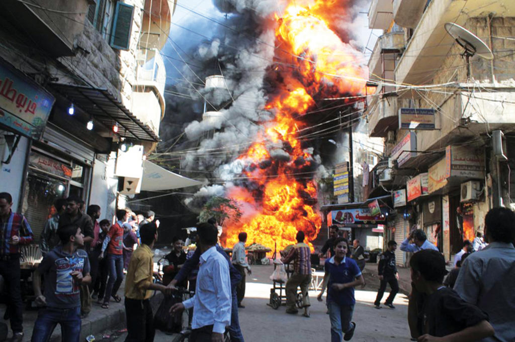 Los residentes corren de un incendio en una tienda de gasolina y aceite en el barrio de Alepo Bustan Al-Qasr, Siria, 2013. (Foto: Reuters/Halem Al-Halabi)
