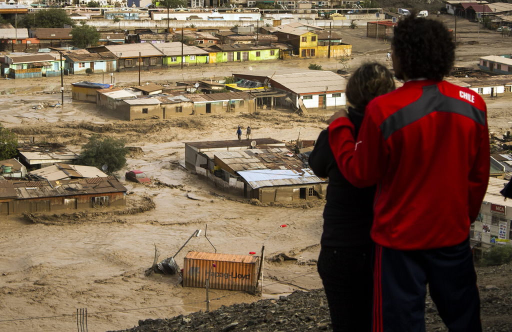 Destrucción.  Fotografía que muestra a dos personas que observan las ríadas que afectaron a la localidad de Diego de Almagro a mil  kilómetros al norte de Santiago de Chile.