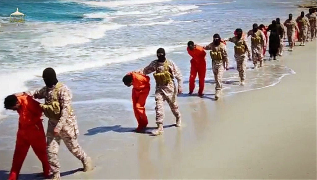 Sangre. Imagen del video difundido, donde encapuchados trasladan en la playa a las víctimas.