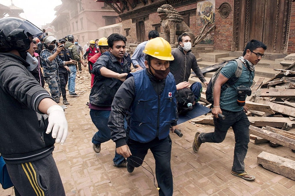 Avance. Rescatistas de la Cruz Roja en Nepal, corren al llevar a una mujer que fue salvada de morir entre los escombros.

