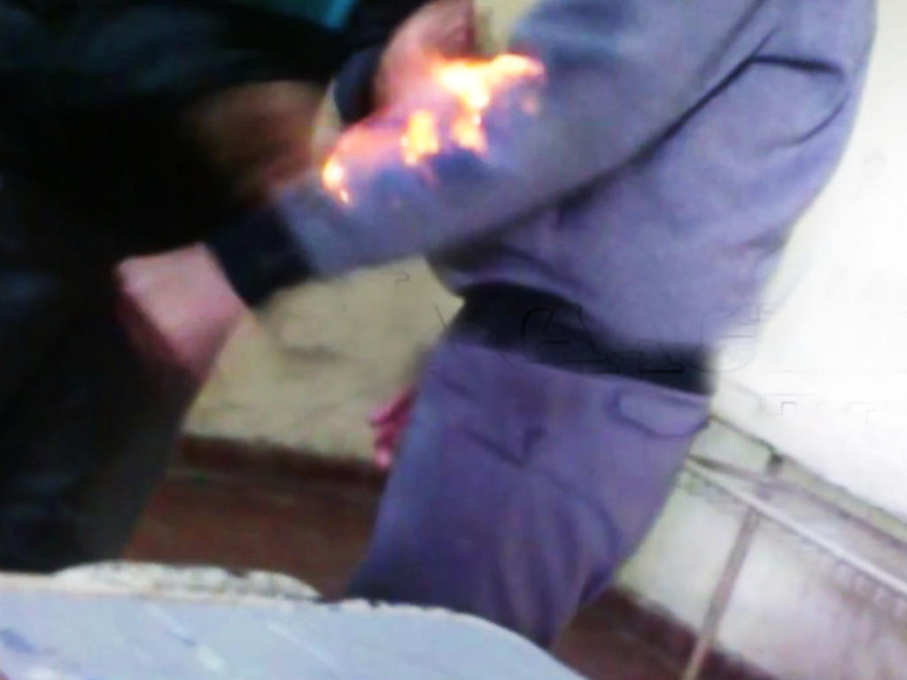 El joven se prende el brazo con su sudadera puesta, sin embargo, el fuego no cesa pese a sus esfuerzos por sofocarlo. (YOUTUBE)