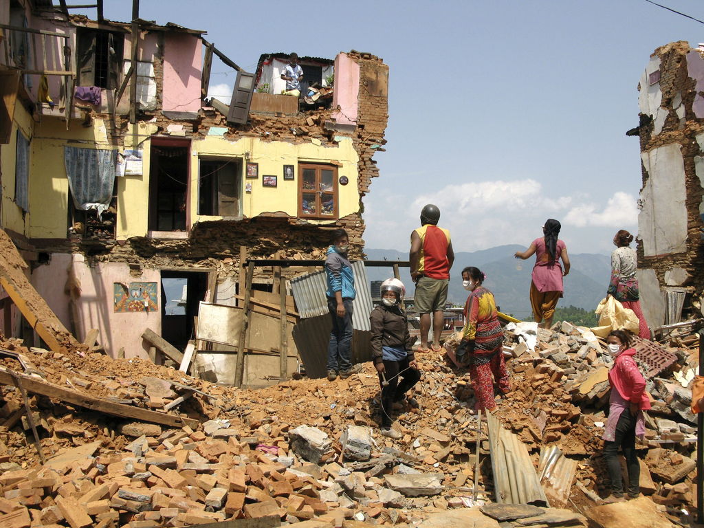 Sismo. Una familia revisa entre los escombros de su vivienda si hay cosas que se puedan rescatar.