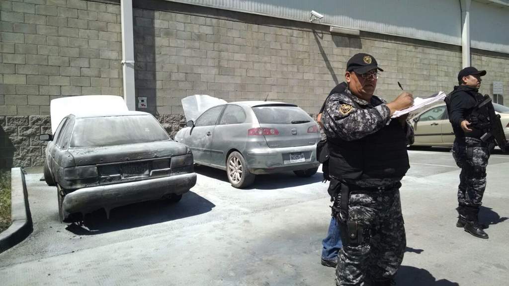 Autos bomba. En la imagen se observa a un oficial levantando un acta ante los dos autos que fueron usados como bombas.