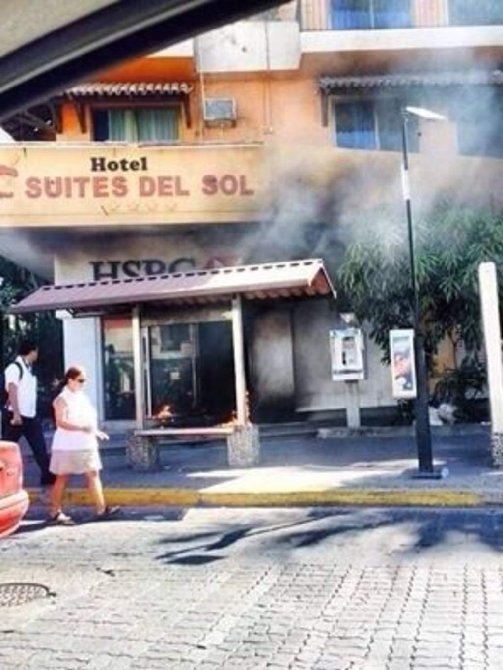 Bancos. En Puerto Vallarta, dos personas pasan mientras observan el incendio de un banco.