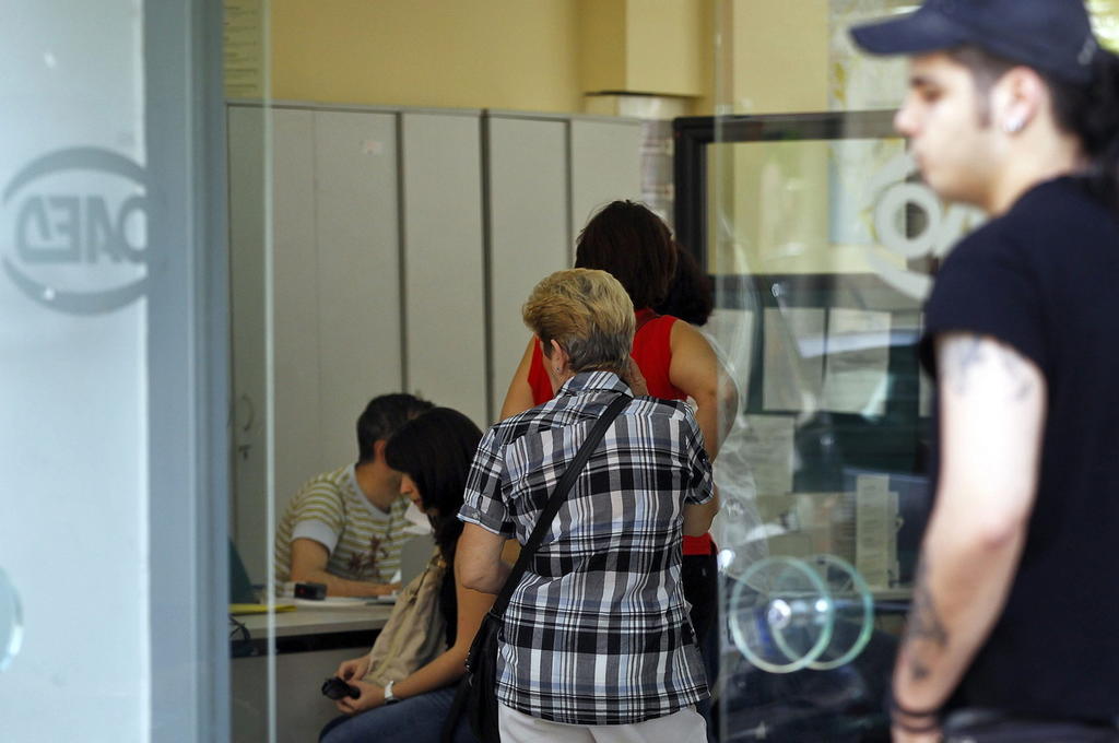 Un grupo de personas hace cola a las puertas de una oficina de empleo en Atenas, Grecia. (ARCHIVO)