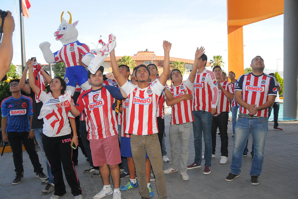 Poco más de 30 aficionados del Guadalajara aguardan afuera de la concentración del Rebaño Sagrado; esperan que su equipo se lleve la victoria en el juego de ida de la semifinal. (EL SIGLO DE TORREÓN) 