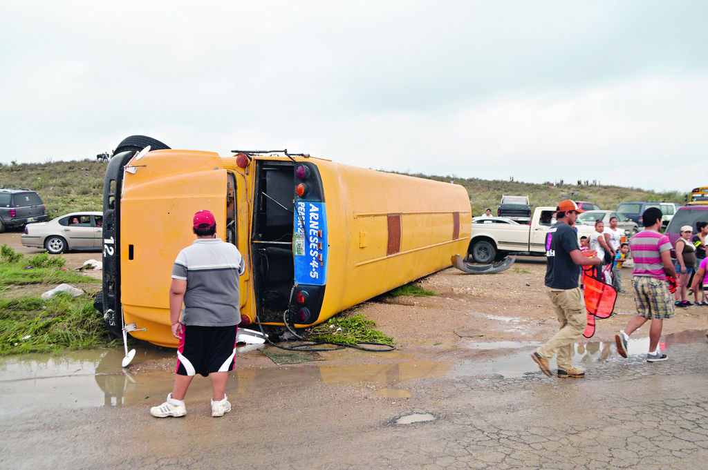 Sufren pérdidas. Víctimas del tornado recogen algunas pertenencias de sus casas dañadas por el fuerte fenómeno natural.