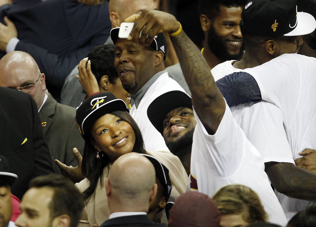 LeBron James (d) de Cavaliers y su esposa, Savannah, celebran tras la victoria sobre Hawks, en el cuarto partido por la final de la Conferencia. (AP)