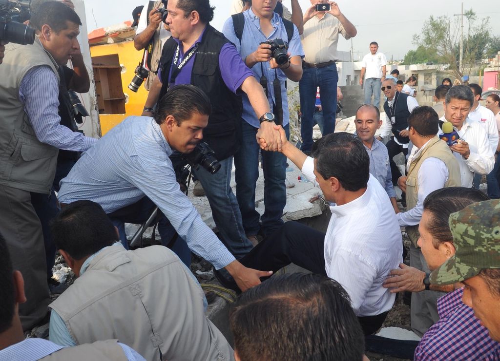 Análisis. Durante el recorrido, el presidente Enrique Peña Nieto es ayudado a subir una estructura destruida para ver las pérdidas.  (Ramón Sotomayor)