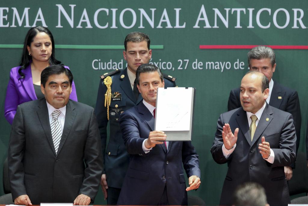El presidente Enrique Peña Nieto, acompañado de los legisladores Miguel Barbosa y Julio César Moreno, muestra el documento que contiene la promulgación de la Reforma Constitucional para crear el Sistema Nacional Anticorrupción. (EL UNIVERSAL)