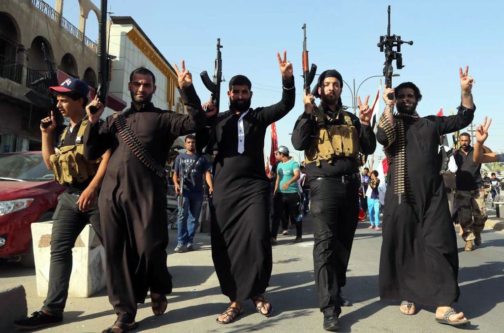 Avances. Un grupo de yihadistas alza las manos como sinónimo de victoria al entrar en una ciudad. 