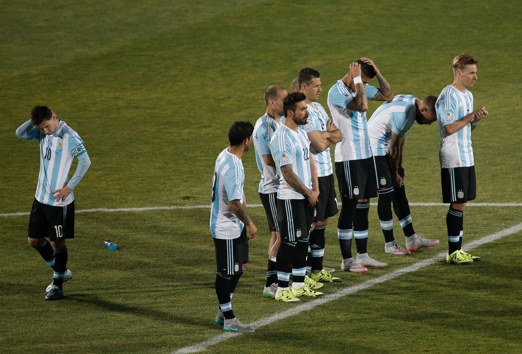 Lionel Messi (i) se lamenta durante la serie de penales, separado del resto de sus compañeros, que observan al tirador en turno. (AP)