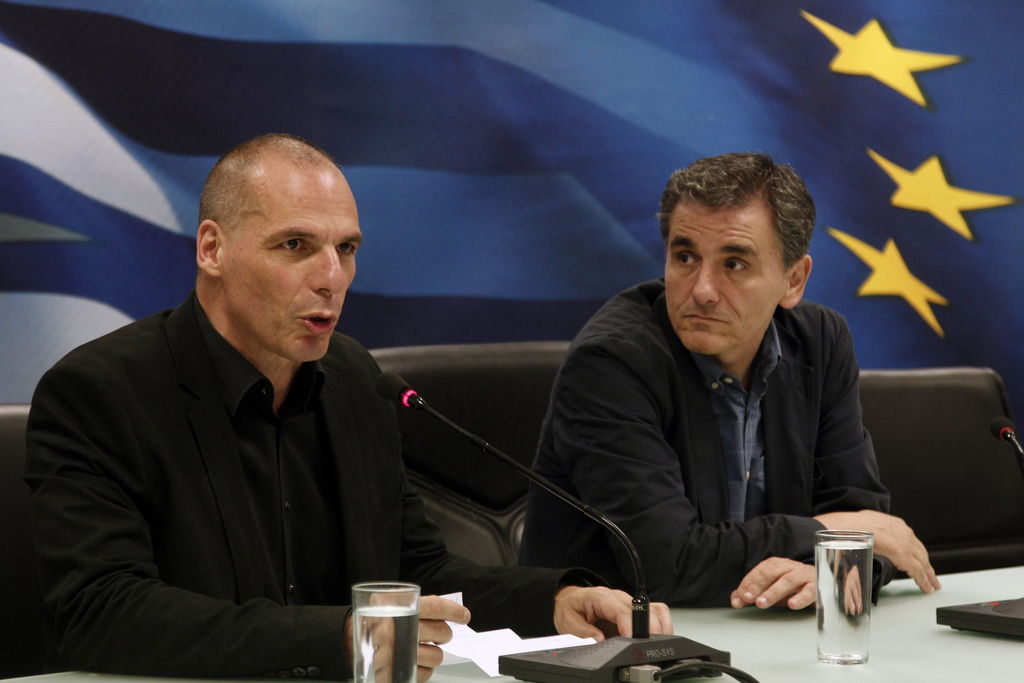 Relevo.  El saliente ministro griego de finanzas Yanis Varoufakis (i) habla junto al nuevo ministro Euclides Tsakalotos durante la ceremonia de posesión en la sede del ministerio en Atenas (Grecia).