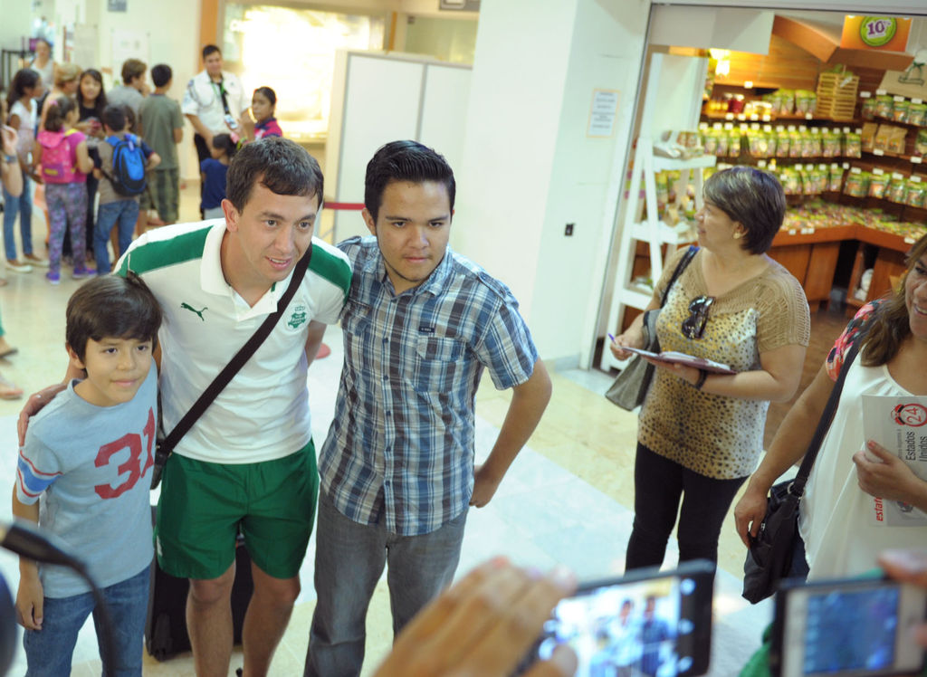 Agustín Marchesín se toma la foto del recuerdo con dos aficionados a su llegada al aeropuerto. (Erick Sotomayor)
