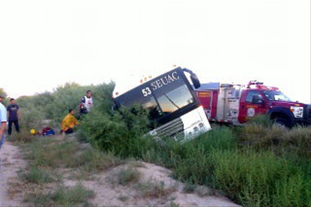 Se salvan. El camión de pasajeros terminó en una zona de terracería, a punto de volcar en su costado derecho.