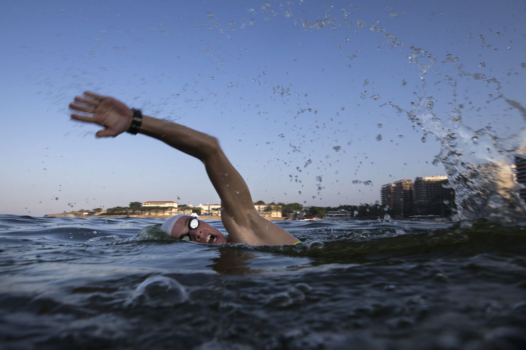 Un atleta entrena en el mar de Copacabana en Brasil pese a advertencias acerca de la limpieza del agua. (AP)