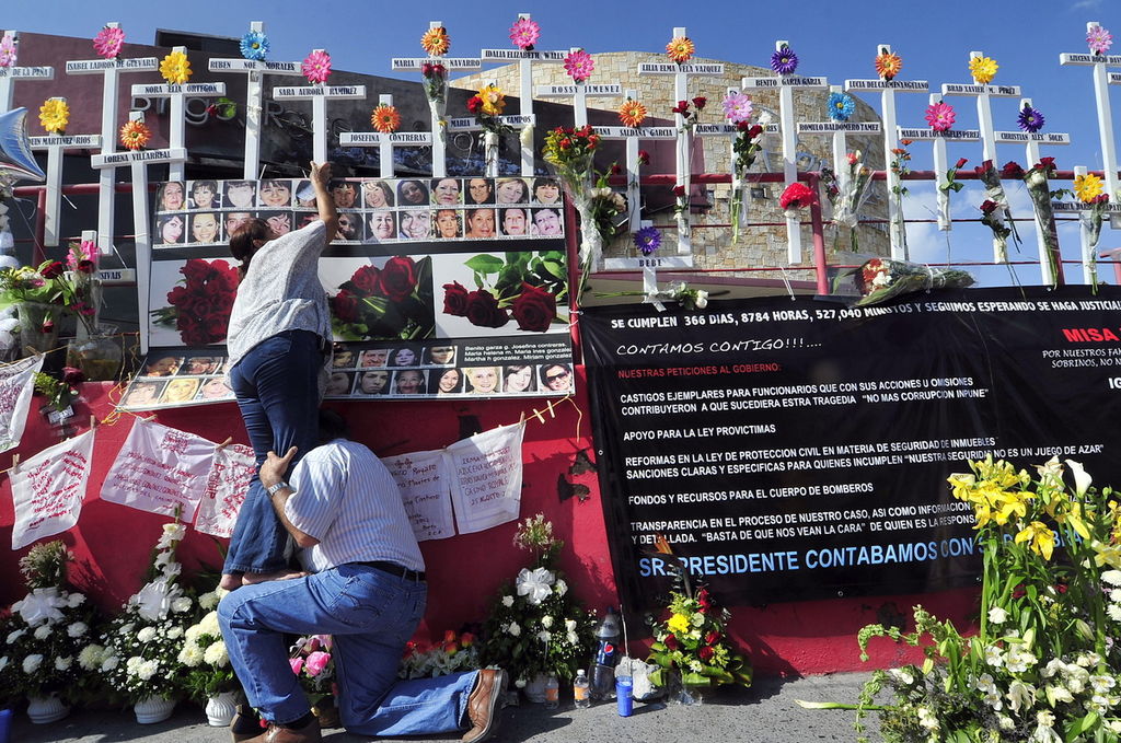 Decenas de personas asisten a un acto realizado frente al Casino Royale, en la ciudad de Monterrey, para conmemorar el primer aniversario del atentado. (EFE)