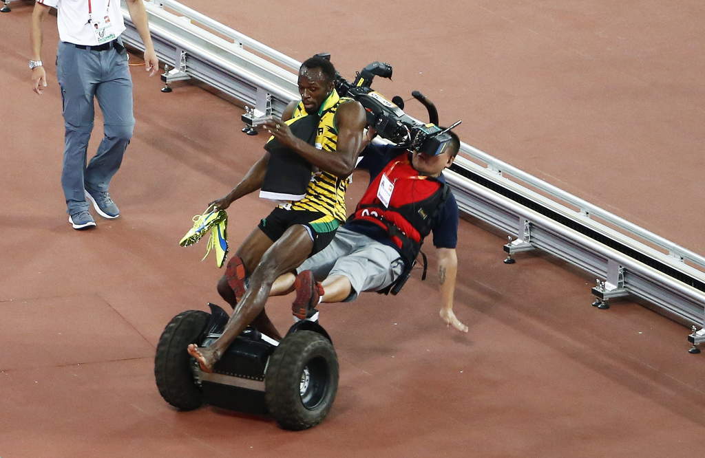 El momento en que Bolt es arrollado por un camarógrafo en un segway. (EFE)