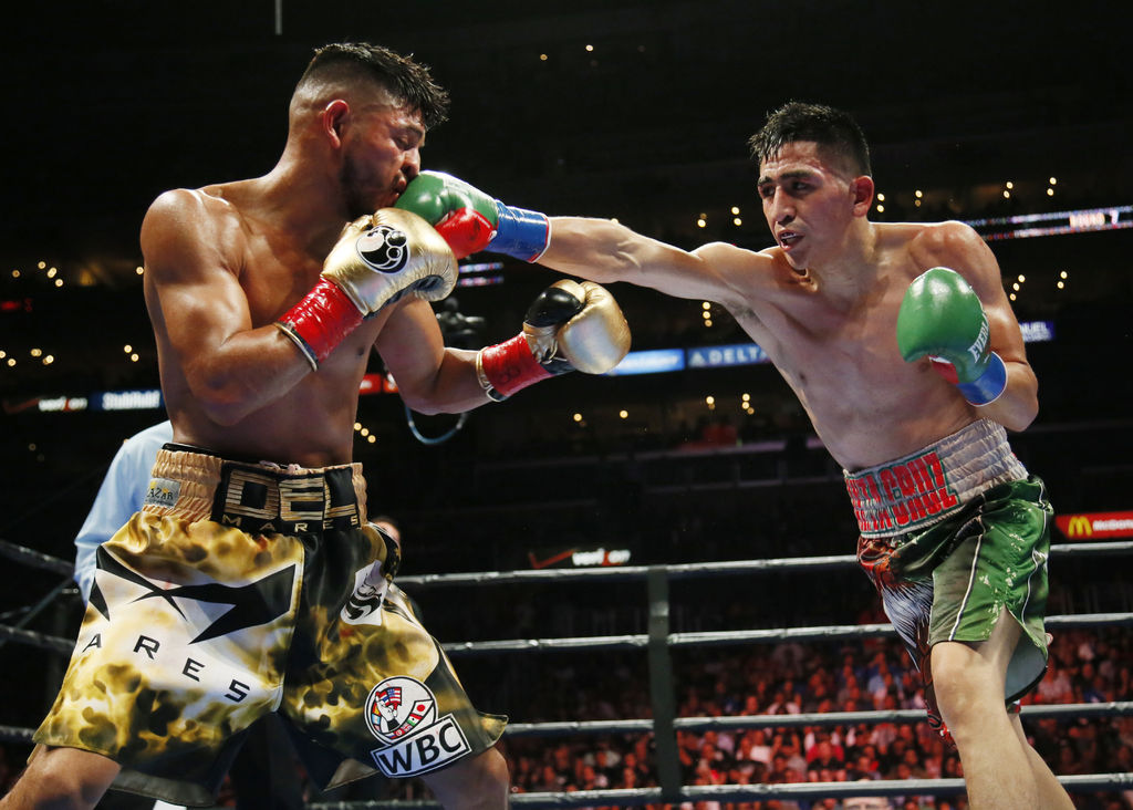 Leo Santa Cruz golpea en el rostro a Abner Mares durante la pelea celebrada ayer en el Staples Center. El 'Terremoto' es nuevo campeón pluma de la Asociación Mundial de Boxeo. (AP)