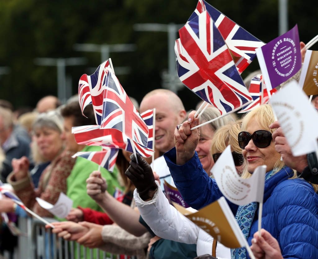Cariño. Los miembros del público esperan la llegada de la reina Isabel II a la ceremonia de apertura de la vía de ferrocarril. (EFE)