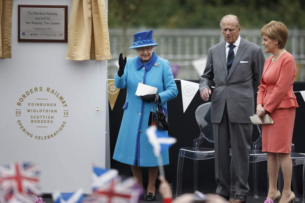 Saludo. La reina Isabel II (i), su esposo, el duque de Edimburgo (c), y la ministra de Escocia,Nicola Sturgeon (d) en acto inaugural. (EFE)