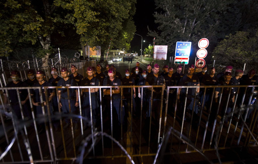 Límite. Policía húngara se pone al borde de una reja donde estarán contenidos los refugiados.