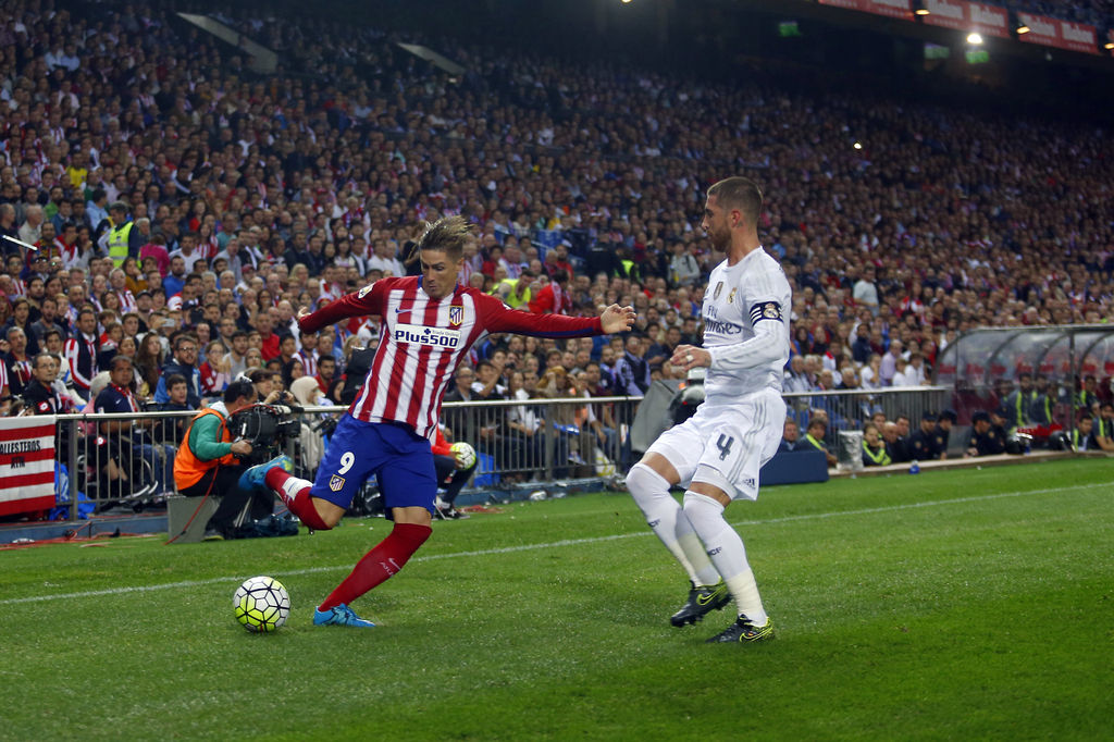 Fernando Torres (i) y Sergio Ramos durante el partido entre el Real Madrid y el Atlético en el estadio Vicente Calderón. (AP)