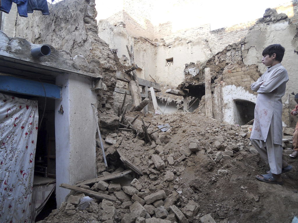 Derrumbe. Un niño observa su vivienda que quedó enterrada tras el derrumbe que causó el sismo. (EFE) 