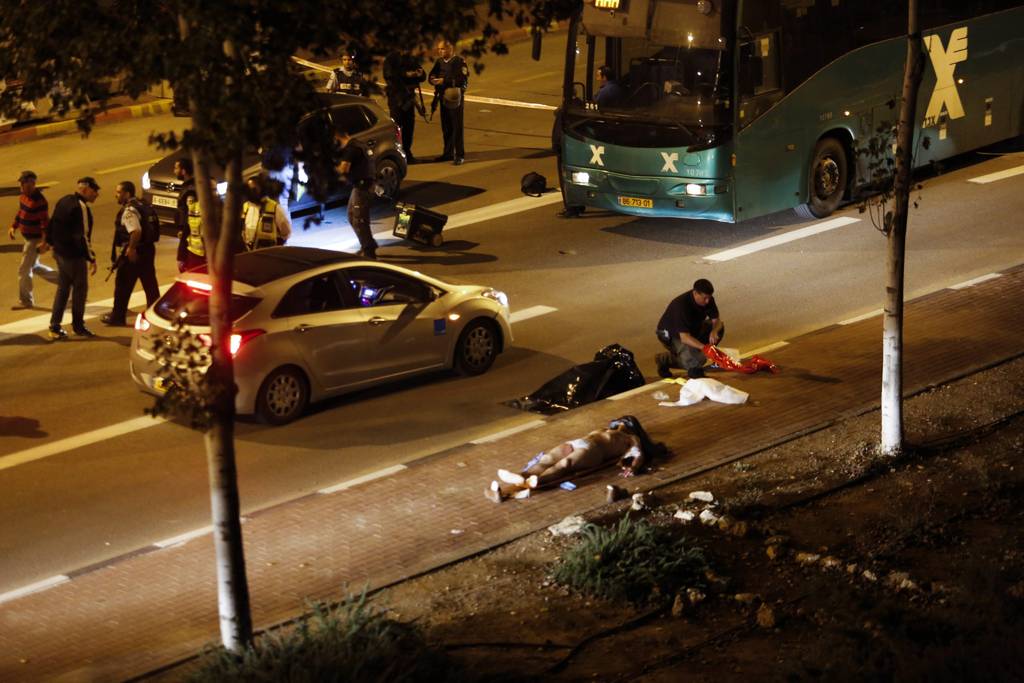 Atentados.  Agentes de policía permanecen junto a los cuerpos de los israelíes asesinados por un palestino.
