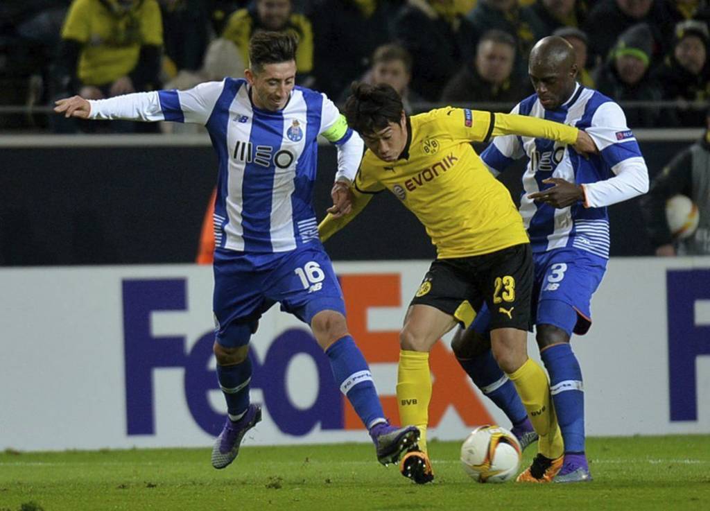 El jugador del Borussia Dortmund Shinji Kagawa (c) lucha por el control del balón con Héctor Herrera (i) y Bruno Martins Indi (d), del Porto. (EFE)