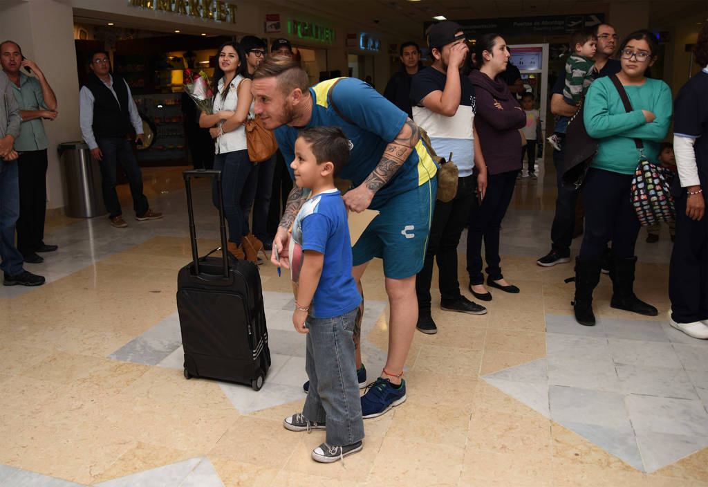 Cristian Campestrini atendió a un pequeño que espera por el equipo del Puebla. Se tomó la foto del recuerdo y le firmó su pancarta. (Jesús Galindo)