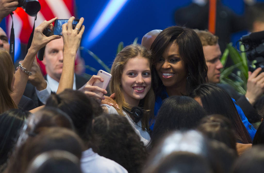 Reunión. La primera dama Michelle Obama se toma una foto con una estudiante en foro con los estudiantes argentinos. (AP)