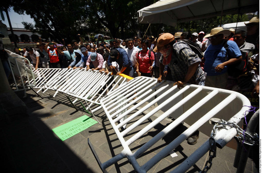 Confrontación. En Oaxaca, integrantes de la CNTE derribaron vallas.
