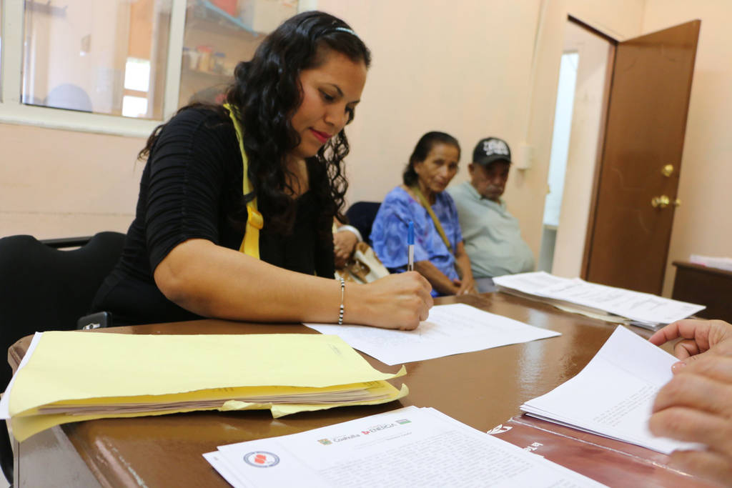Firma. Las familias que se beneficiaron del programa de escrituración, acudieron a firmar los documentos. (CORTESÍA)
