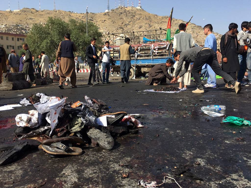 Restos. Algunos sobrevivientes recogían las pertenencias de las víctimas del atentado en Kabul.