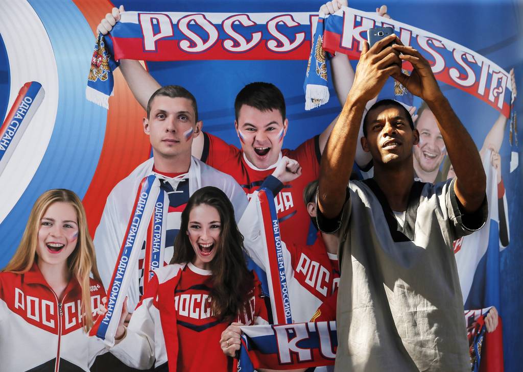 Un hombre se toma un selfi frente con una imagen de deportistas rusos en Río de Janeiro. La delegación de Rusia ha quedado mermada luego de los diversos castigos a sus atletas por dopaje. (AP)