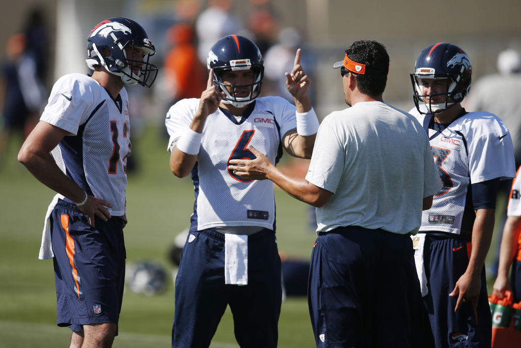 El entrenador de mariscales de campo de los Broncos de Denver, Greg Knapp, platica con los tres quarterbacks del equipo en un entrenamiento. (AP)