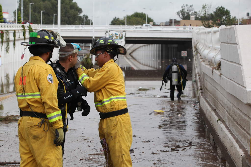 Rescate. Miembros del cuerpo de Bomberos de Durango se preparan para rescatar cadáveres o vehículos en el Puente Negro que une al centro de la ciudad con el norte.
(EL SIGLO DE TORREÓN)