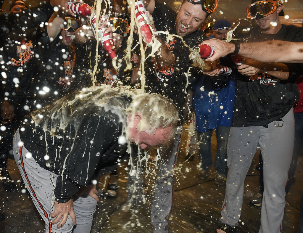 Los jugadores de Orioles bañan a su mánager Buck Showalter tras obtener el comodín de la Liga Americana. (AP)