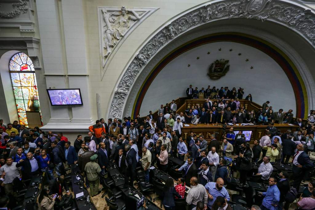 Bajo el grito de 'el pueblo unido jamás será vencido' varios lograron burlar las cuatro alcabalas que existen para ingresar al salón de debates del Parlamento. (EFE) 