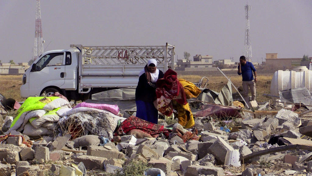 Una mujer camina sobre los escombros a los que ha quedado reducida su casa tras la ocupación del grupo Estado Islámico. (ARCHIVO)