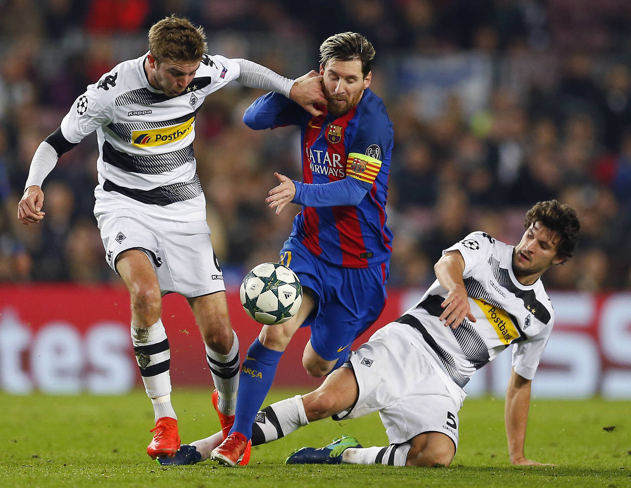 Lionel Messi pasa entre dos adversarios del Borussia Moenchengladbach, en el encuentro de ayer.  (AP)