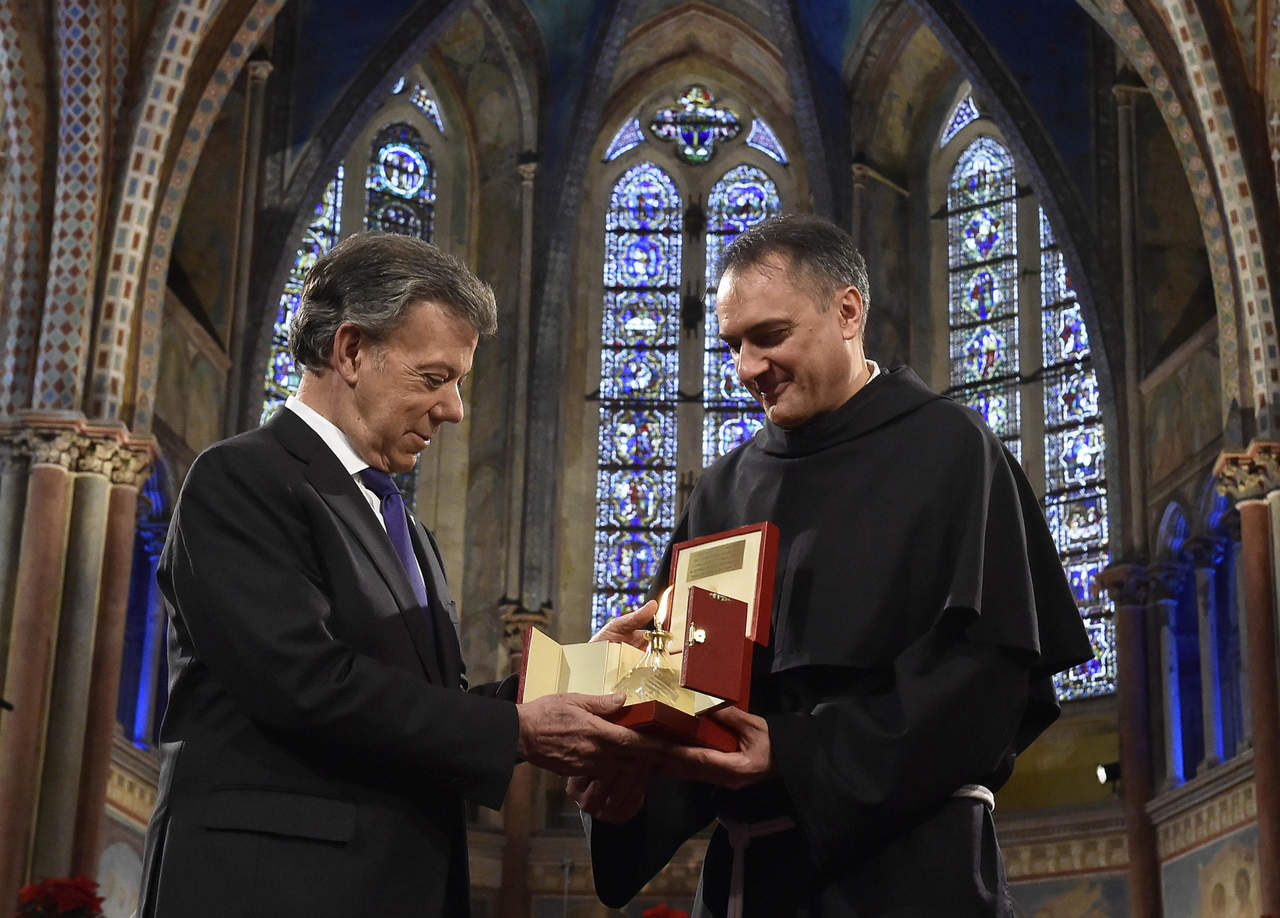 Durante la entrega del llamado 'Nobel católico de la paz', que otorga la Orden de los Franciscanos de Asís, Santos, como hiciera en Oslo, dedicó el premio a los millones de víctimas del conflicto. (EFE)