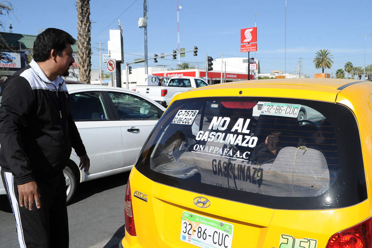 Decenas de automovilistas se sumaron a la protesta permitiendo que se les colocaran pintas de 'No al gasolinazo'.  (RAMÓN SOTOMAYOR) 